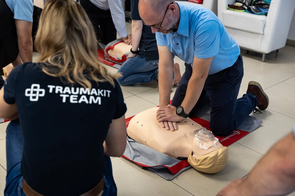 Uczestnik szkolenia ćwiczy RKO na fantomie pod okiem instruktorki TRAUMAKIT